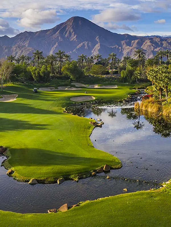 golf-course-with-artificial-lake-with-mountains-in-the-background